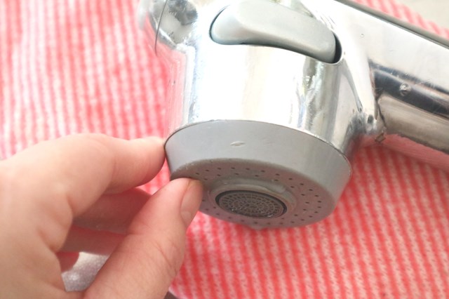 蛇口の水垢を爪で擦る