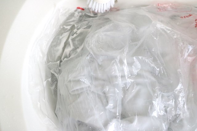 作業服をつけた液にビニールのフタをかぶせる